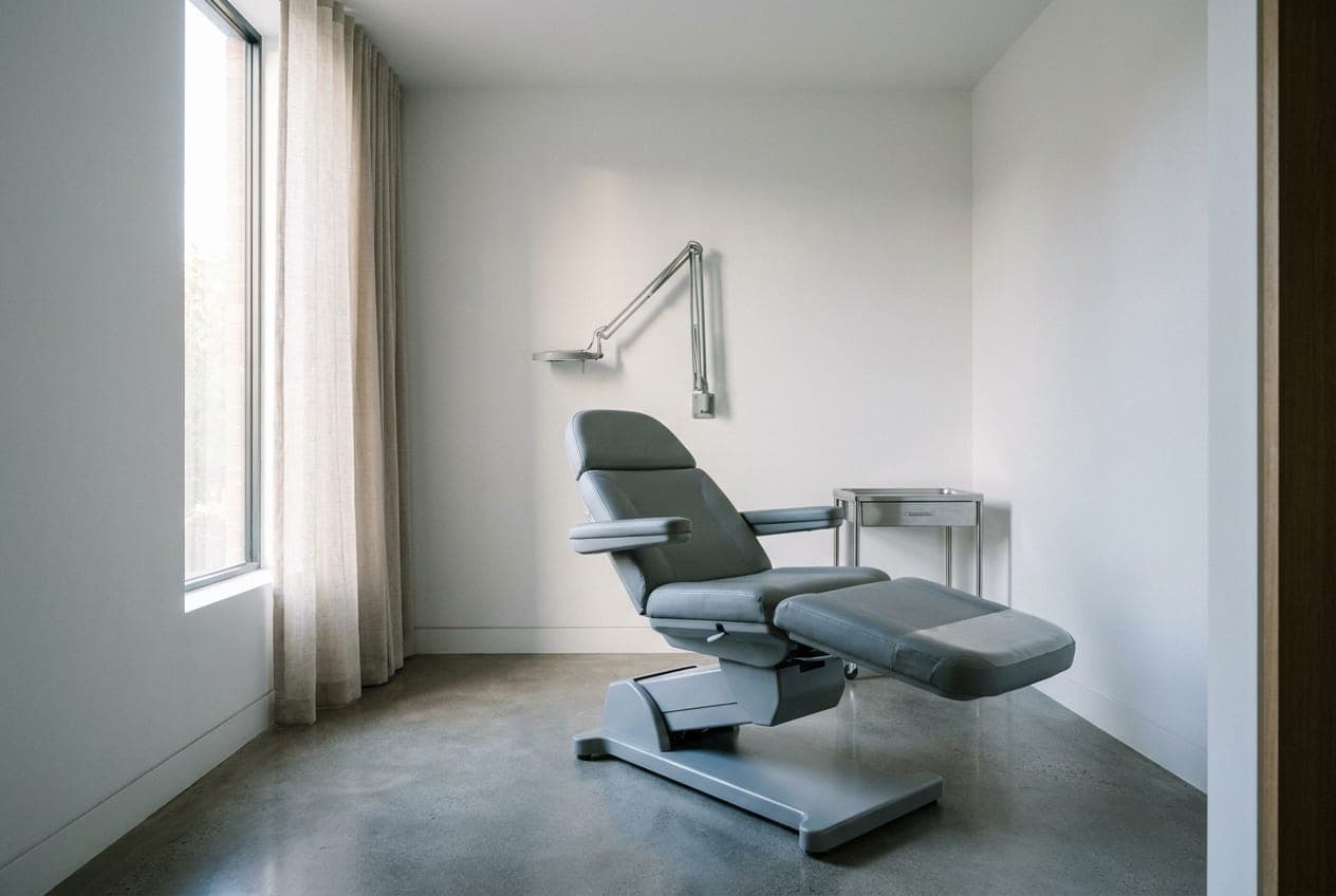The Lumera injectable suite — a cool grey treatment chair in cool daylight